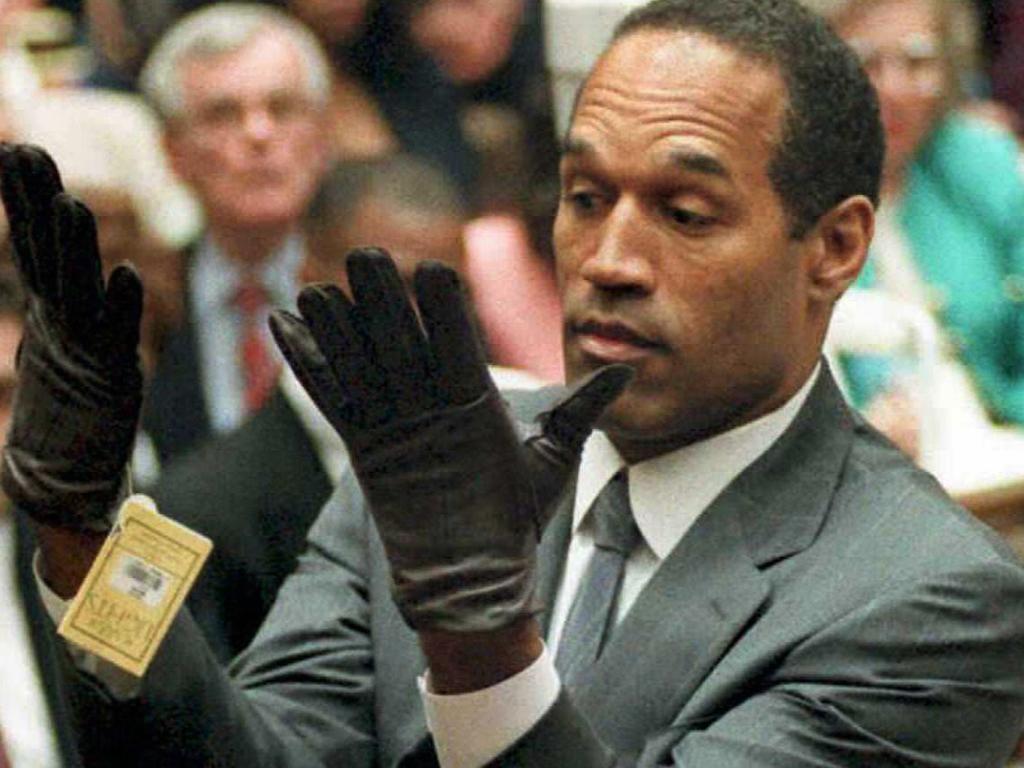 OJ Simpson trying on the infamous, ill-fitting leather gloves linked to the murders during his trial. Picture: Supplied