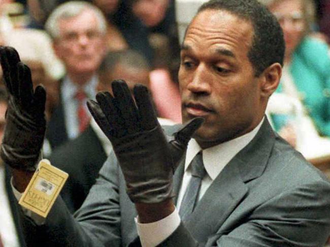 OJ Simpson trying on the infamous, ill-fitting leather gloves linked to the murders during his trial. Picture: Supplied