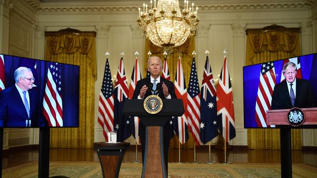 US President Joe Biden makes the announcment flnaked by displays of the Australian and British prime ministers. Picture: AFP