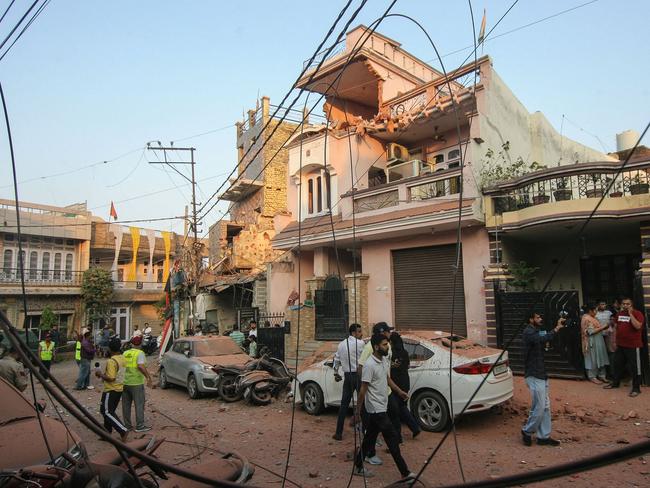 Residents gather near a house that was damaged by Pakistani artillery shelling in Jammu on May 10. Picture: AFP