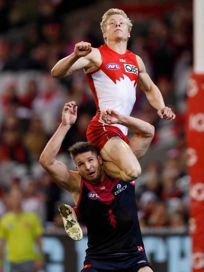 MELBOURNE, AUSTRALIA - AUGUST 12: Isaac Heeney of the Swans takes a spectacular mark over Jesse Hogan of the Demons during the 2018 AFL round 21 match between the Melbourne Demons and the Sydney Swans at the Melbourne Cricket Ground on August 12, 2018 in Melbourne, Australia. (Photo by Michael Willson/AFL Media)