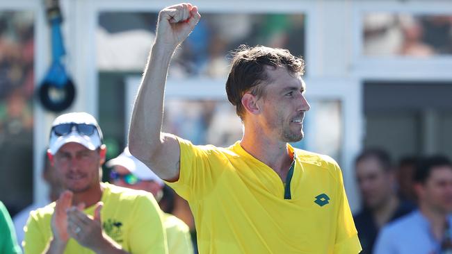 John Millman celebrates ahead of Australian captain Lleyton Hewitt after beating Damir Dzumhur of Bosnia-Herzegovina in the opening Davis Cup runner. Picture: Scott Barbour/Getty Images