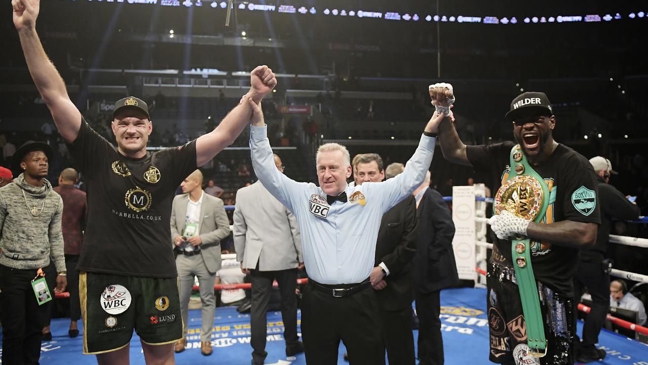 Tyson Fury, left, of England, poses with Deontay Wilder, right, along with referee Jack Reiss after their WBC heavyweight championship match.