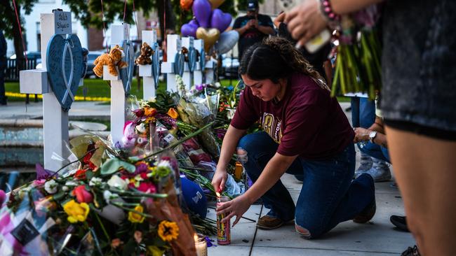 A woman lights a candle at a makeshift memorial outside Uvalde County Courthouse in Uvalde. Picture: Chandan Khanna/ AFP.