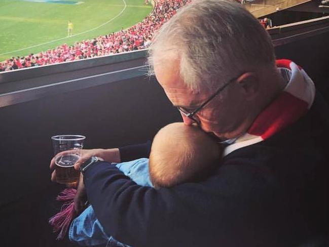 Prime Minister Malcolm Turnbull holds his granddaughter at the Sydney Swans v Essendon final at the SCG on Saturday.