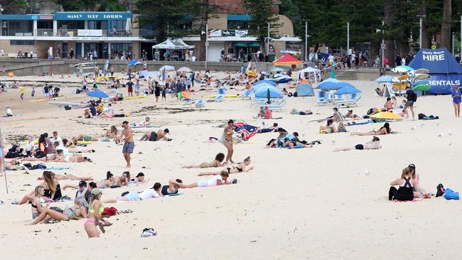 People at Manly beach, 21st March, 2020. The council will set up extra flagged swimming areas on beaches to help keep people apart. Picture: Damian Shaw