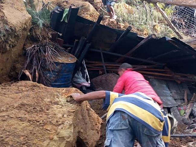 Locals look into a demolished house at the site of a landslide at Yambali Village in the region of Maip Mulitaka, in Papua New Guinea's Enga Province. Picture: AFP