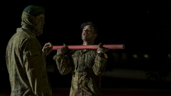 An Australian Army special forces soldier (left) supervises Commando candidates during an early morning physical training session.