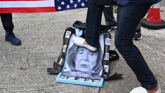 A pro-Beijing protester stamps on an image of US House Speaker Nancy Pelosi at a protest outside the US Consulate in Hong Kong on August 3, 2022 after Pelosi arrived in Taiwan as part of a tour of Asia that has inflamed tensions.