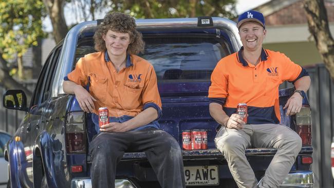 Adelaide ceiling contractors Ryan Fraser, left, and Dale Evans share a six-pack of what South Australians call ‘red cans’. Picture: Roy Van Der Vegt