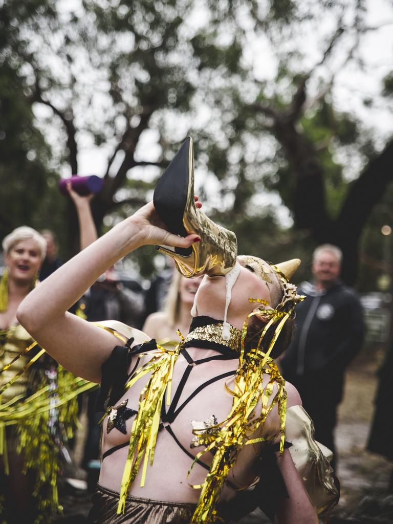 A gold unicorn impersonator does a Shoey. Pic by Theresa Harrison