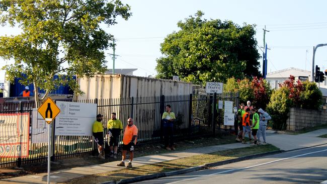 Some of the workers waiting to hear how their day will play out after the fire at Southport State High School closed a construction site. Picture: Luke Mortimer