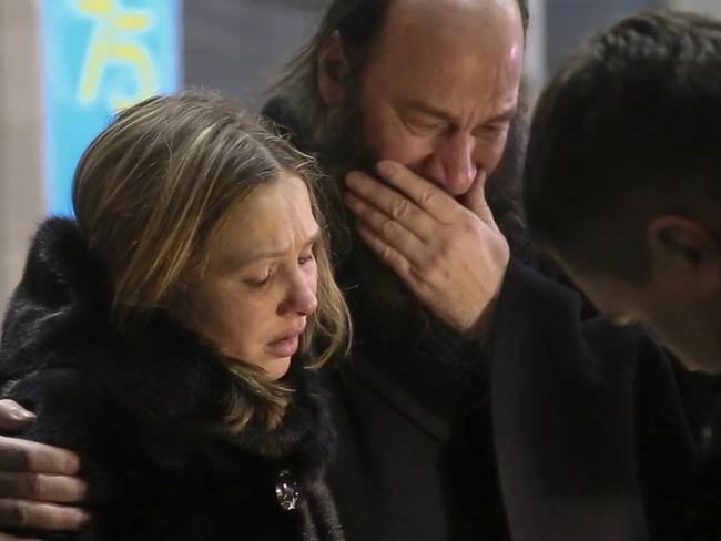 Relatives and friends of those on the Saratov Airlines airline plane that crashed near Moscow's airport comfort each other while gathering at an airport outside Orsk, Russia. Picture: Orsk.ru/AP