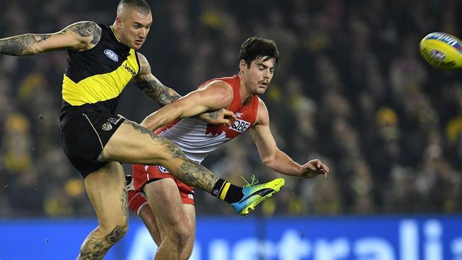 Reigning Browlow medallist Dustin Martin manages to get his kick away despite the close attention from super stopper George Hewett. Picture: AAP