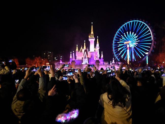 People wearing face masks attend a New Year's countdown at an amusement park in Beijing on January 1, 2022. Picture: Jade GAO / AFP.