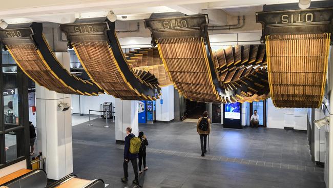 Commuters walk under an installation by artist Chris Fox, titled "Interloop", a physical reinterpretation of the historic wooden-stepped escalators from Wynyard station. Picture: AAP Image/Brendan Esposito.