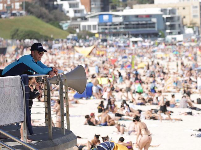 SYDNEY, AUSTRALIA - NewsWire Photos OCTOBER 05, 2020 - A lifeguard pictured watching the crowd at Bondi Beach on Monday October 05, 2020 as temperatures reached 30 degrees. Picture: NCA NewsWire / Christian Gilles