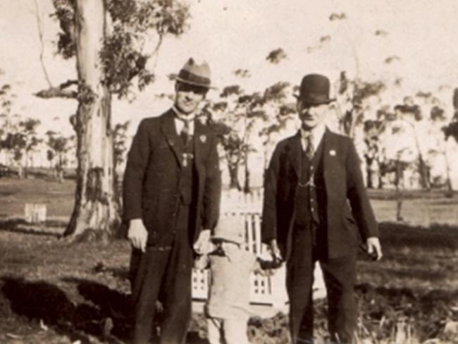 Returned serviceman Les Escott, left, with his son Reg, and his father Walter, at the tree planted for his brother, Gunner Reg Escott, at the northern end of the Soldiers' Memorial Avenue in Hobart.