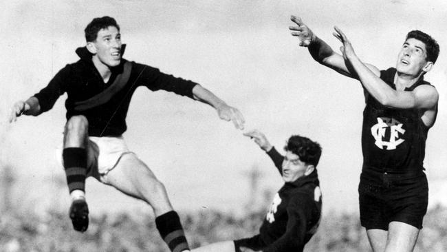 Ron Evans, has a kick for goal against Essendon in 1960.