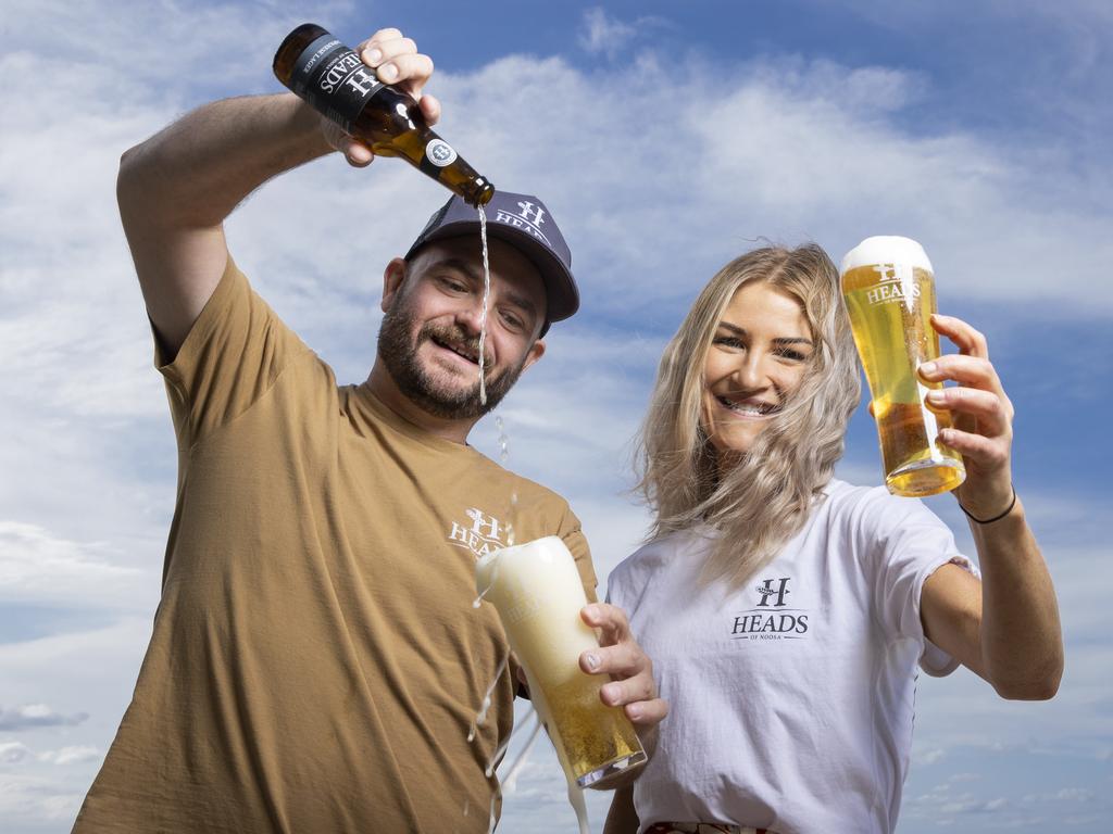 Heads of Noosa co-founder Craig Masterton and Jess Smith get stuck into some craft beer at Noosa Main Beach. Picture Lachie Millard