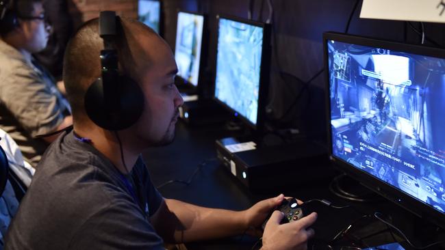 Video game fans play Microsoft's video game console "Xbox One" at a video game cafe in Tokyo on September 3, 2014 on the eve of the launch in Japan. Microsoft Japan will launch the company's latest video game console to the Japanese market on September 4. AFP PHOTO / Yoshikazu TSUNO