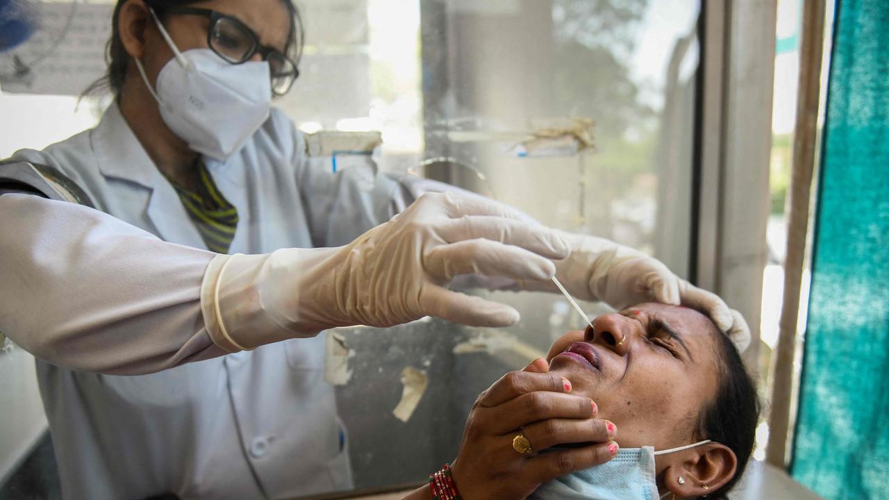 A health worker collects a nasal swab sample from a woman during a Covid-19 coronavirus screening in India. Picture: NARINDER NANU / AFP.