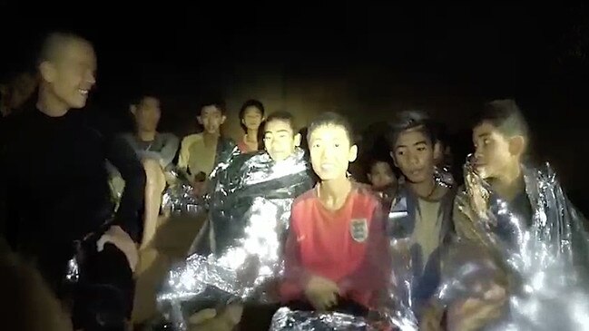 Members of a soccer team in Tham Luang cave with a Thai Navy SEAL. Picture: Getty Images