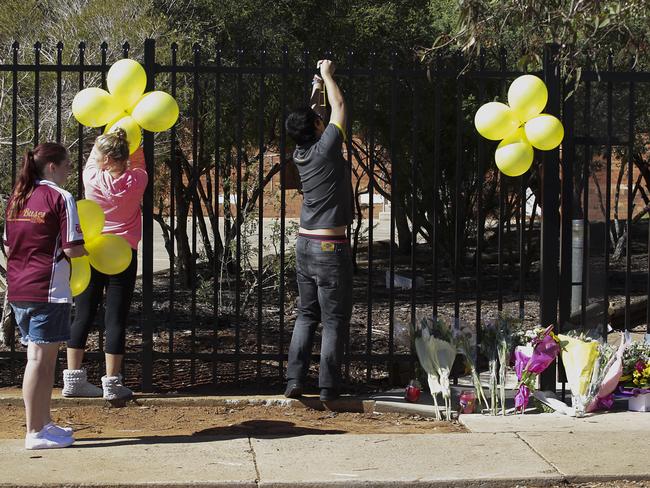 Students hang balloons tribute for their murdered teacher Stephanie Scott on the fence of Leeton High School. Picture: Chris McKeen.