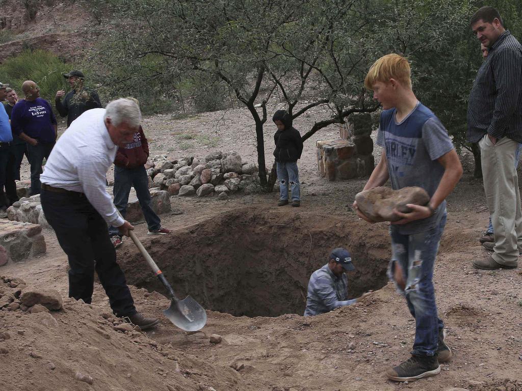 A boy helps as men dig the mass grave at the family cemetery in La Mora. Picture: Marco Ugarte/AP