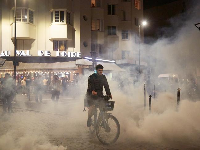 A man cycle through clouds of tear gas fired by anti-riot police officers as thousands of supporters of the Popular Front march in Paris. Picture: Pierre Crom/Getty Images