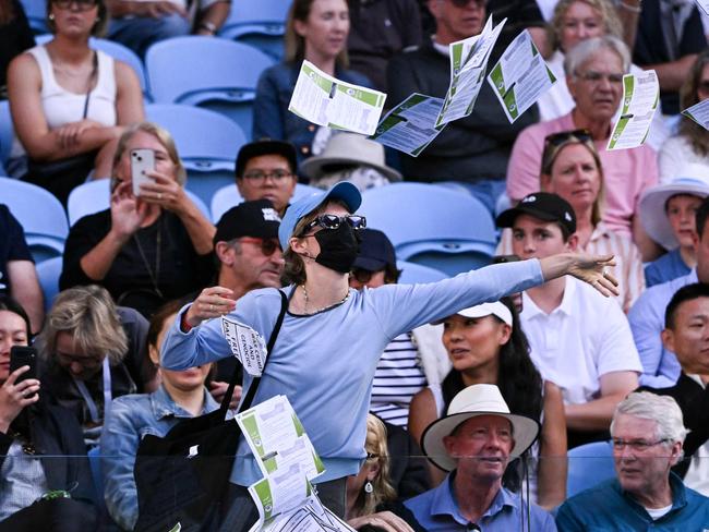 TOPSHOT - A pro-Palestinian protester throws leaflets onto the court during the men's singles match between Britain's Cameron Norrie and Germany's Alexander Zverev on day nine of the Australian Open tennis tournament in Melbourne on January 22, 2024. (Photo by WILLIAM WEST / AFP) / -- IMAGE RESTRICTED TO EDITORIAL USE - STRICTLY NO COMMERCIAL USE --