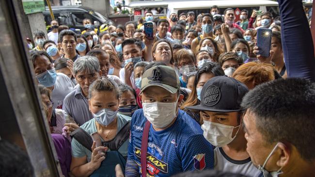 Filipinos hoping to buy face masks crowd outside a medical supply shop that was raided by police for allegedly hoarding and overpricing the masks, as public fear over China's Wuhan coronavirus grows.