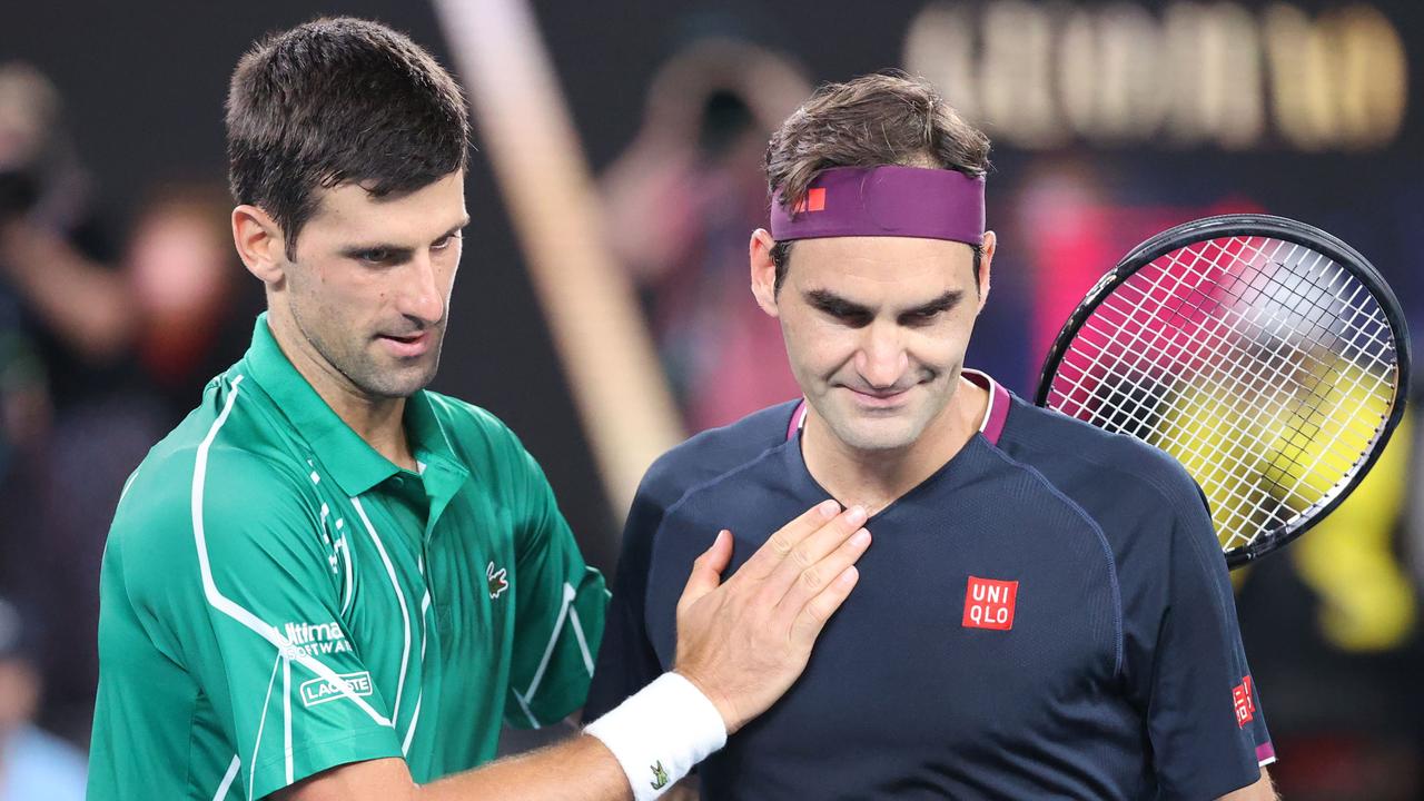 TOPSHOT – Serbia's Novak Djokovic (L) pats Switzerland's Roger Federer after his victory during their men's singles semi-final match on day eleven of the Australian Open tennis tournament in Melbourne on January 30, 2020. (Photo by DAVID GRAY / AFP) / IMAGE RESTRICTED TO EDITORIAL USE – STRICTLY NO COMMERCIAL USE