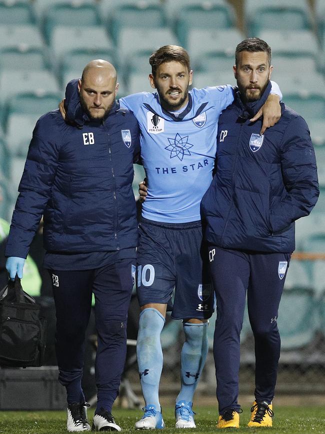 Milos Ninkovic of Sydney walks from the field injured after the tackle by Akbari. Picture: Mark Metcalfe/Getty Images