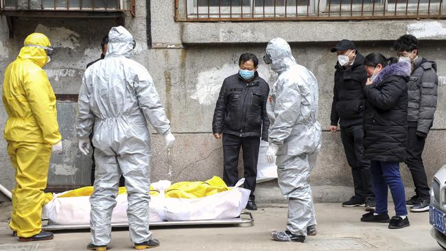 Funeral home workers remove the body of a person suspected to have died of coronavirus in Wuhan. Picture: AP