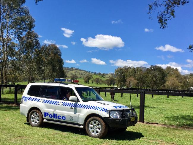 A police car leaves the idyllic property on which three men lost their lives when the car they were in was involved in an accident.