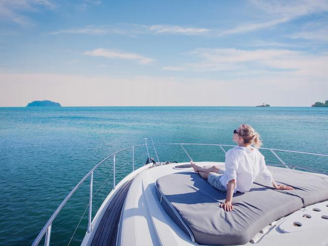 beautiful woman enjoying luxurious yacht cruise, sea travel by luxury boat; rich lifestyle wealth generic