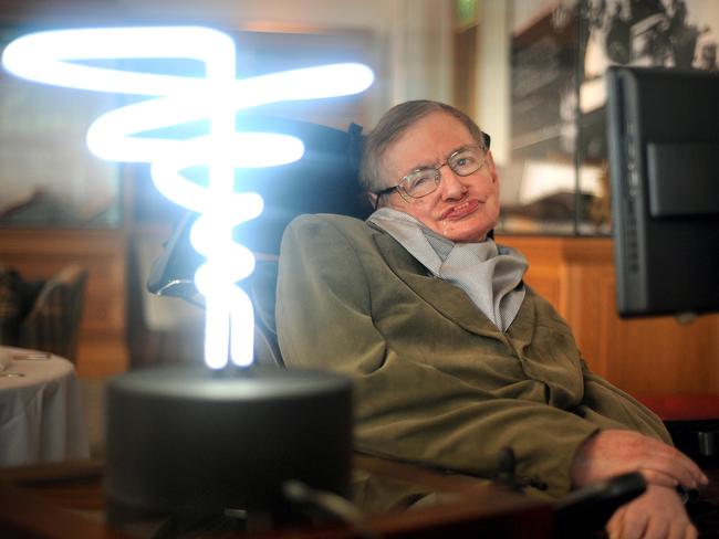 Professor Stephen Hawking poses beside a lamp titled 'black hole light' by inventor Mark Champkins, presented to him during his visit to the Science Museum in London. Picture: AP