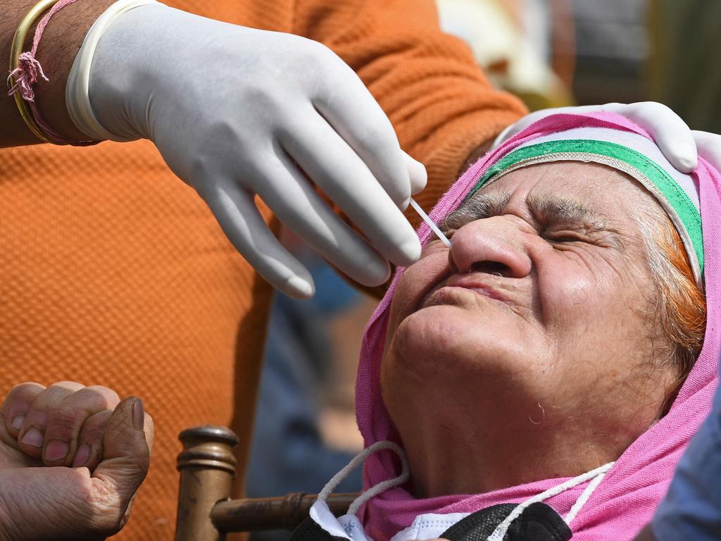 A health worker takes a nasal swab sample from a woman to test for the COVID-19 at a testing centre in Srinagar, India. Picture: Tauseef Mustafa/AFP