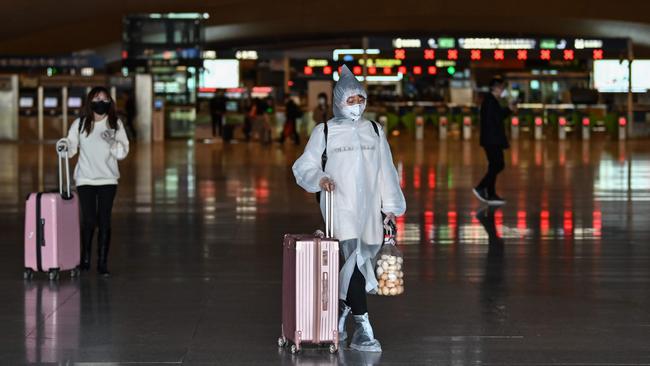 People wearing face masks arrive at the railway station in Wuhan. Picture: AFP