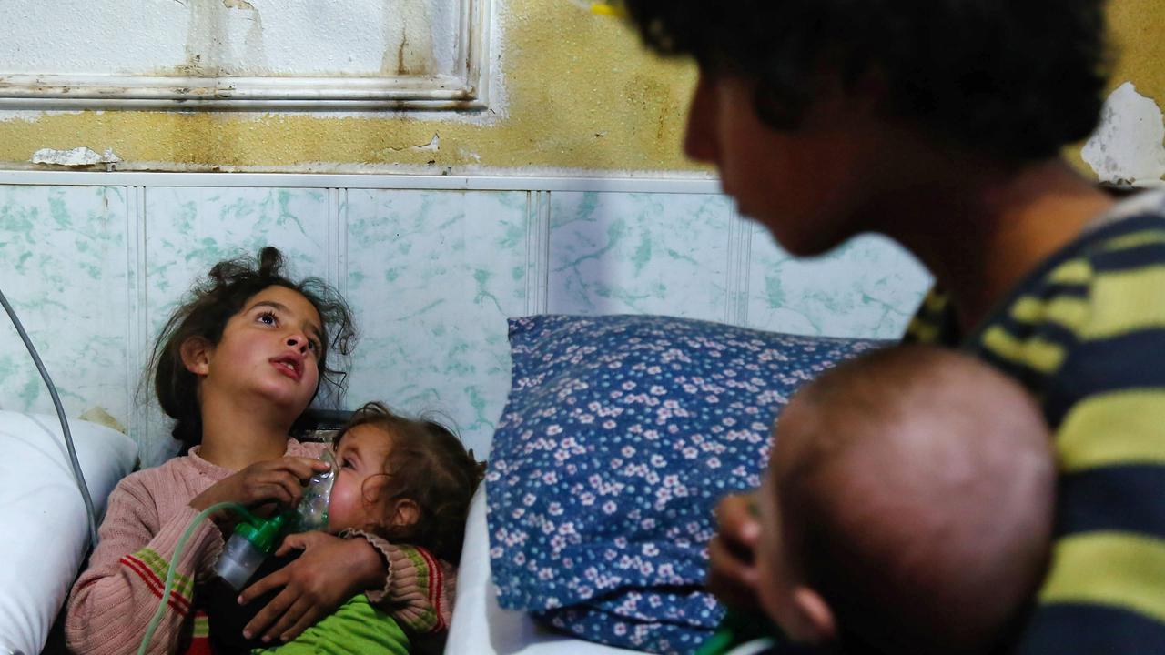 A Syrian girl holds an oxygen mask over the face of an infant at a makeshift hospital following a gas attack in Damascus in 2018. Picture: Hasan Mohamed/AFP