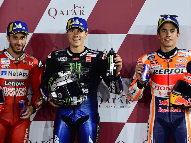 Monster Energy Yamaha MotoGP's Maverick Vinales of Spain (C), who clocked the best time ahead of Mission Winnow Ducati's Andrea Dovizioso (L) and Repsol Honda's Marc Marquez of Spain (R), poses with them at the end of the qualification session at Losail track in Doha on March 9, 2019 ahead of the season's start at Qatar MotoGP grand prix on March 10. (Photo by GIUSEPPE CACACE / AFP)