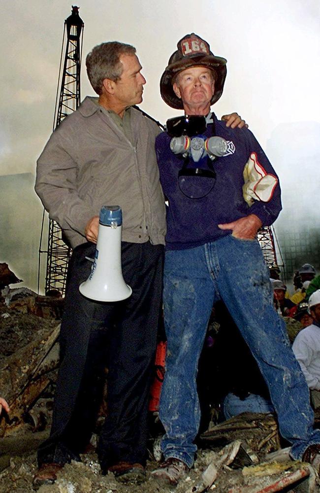 Former US President George W. Bush puts his arms around retired firefighter Bob Beckwith while standing in front of the World Trade Centre in New York. Picture: Supplied