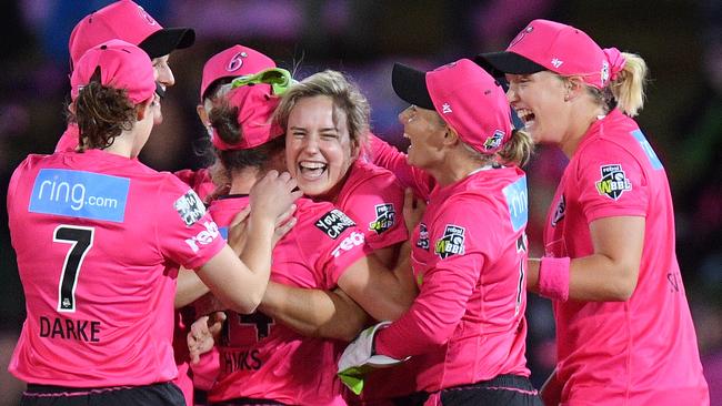 Ellyse Perry of the Sixers (centre) celebrates with teammates after taking the wicket of Rachel Priest of the Thunder during the last WBBL.