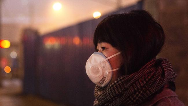 A Chinese woman wears a mask as protection as Beijing’s air quality deteriorates. Picture: Kevin Frayer/Getty