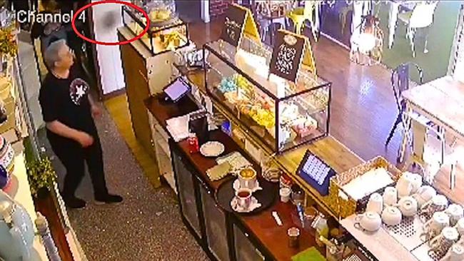 A red circle shows an airborne dinner plate at Capalaba’s Whisky Business Cafe which is owned by Kylie Baker, who is also pictured in the image, which was taken from cafe video footage. Picture: Contributed.