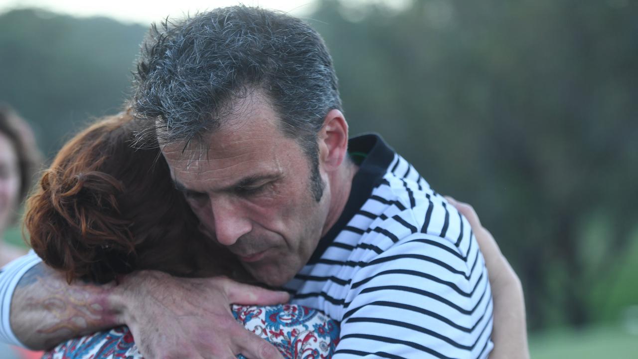 Theo Hayez's father Laurent Hayez is pictured embracing community members at the Byron Bay Golf Course.