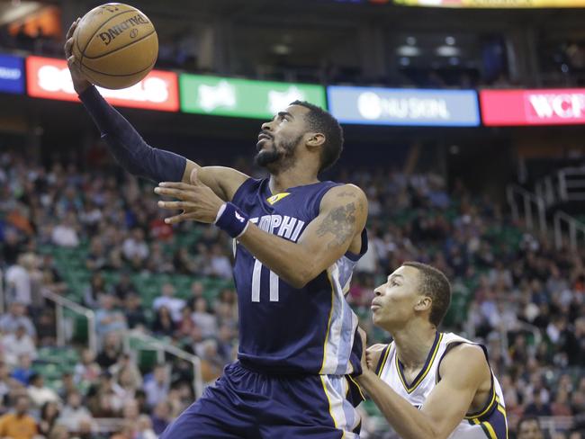 Grizzlies guard Mike Conley lays the ball up as Dante Exum defends.