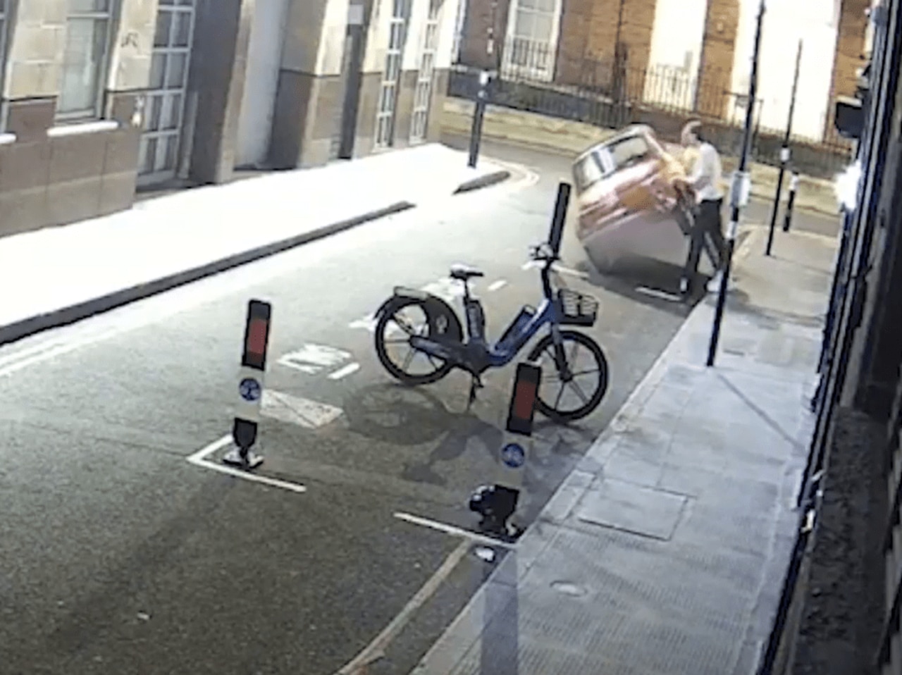 After failing to get in, the pair then lift up the car, raising it high above the road. Picture: Supplied