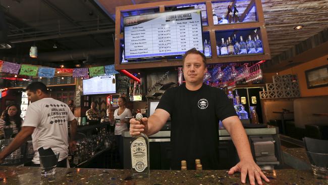 Frank Miller, a partner in a series of eight bars in San Diego, shows off some of the tequila collection at The Blind Burro. Picture: Lenny Ignelzi/AP